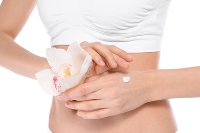 Young woman with flower applying hand cream on white background, closeup. Beauty and body care