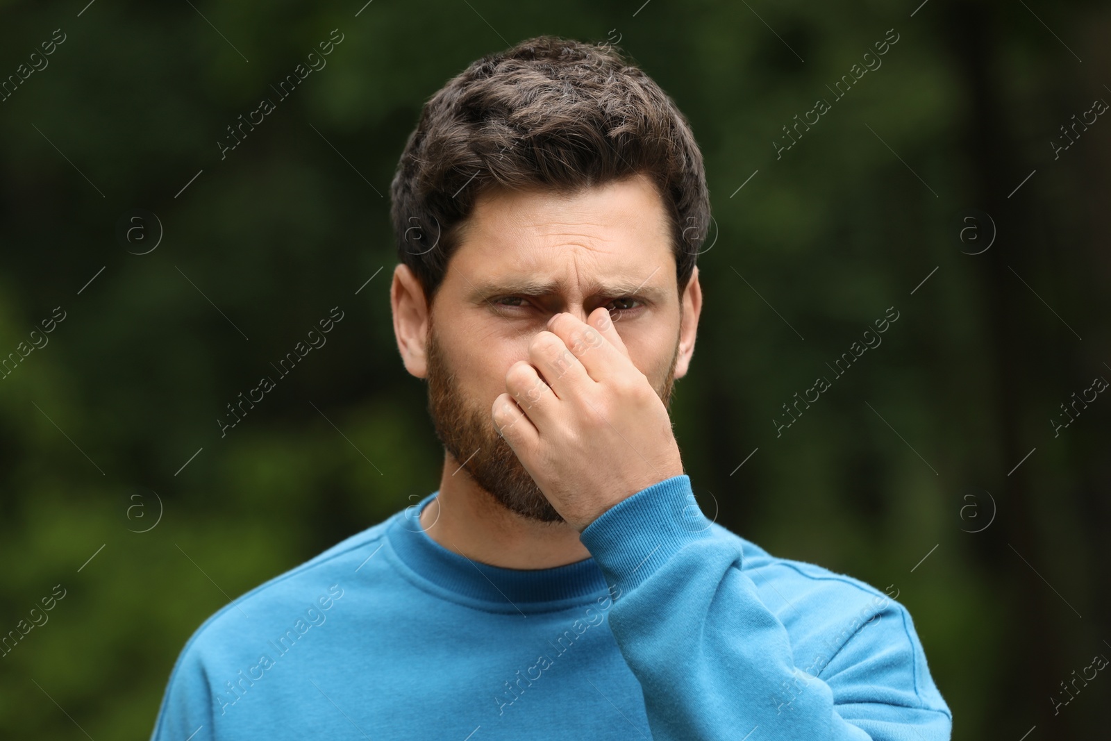 Photo of Man suffering from seasonal spring allergy outdoors