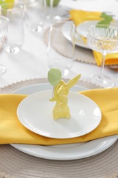 Festive table setting with cutlery, plate and bunny figure. Easter celebration