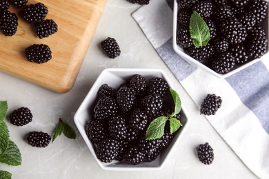 Flat lay composition with tasty blackberries on grey marble table