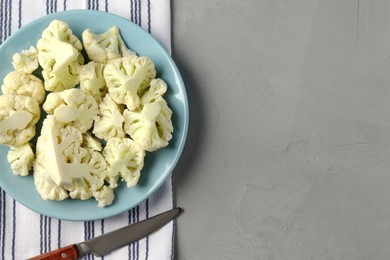 Photo of Plate with cut fresh raw cauliflower on light grey table, flat lay. Space for text