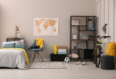 Photo of Stylish teenager's room interior with comfortable bed and sports equipment