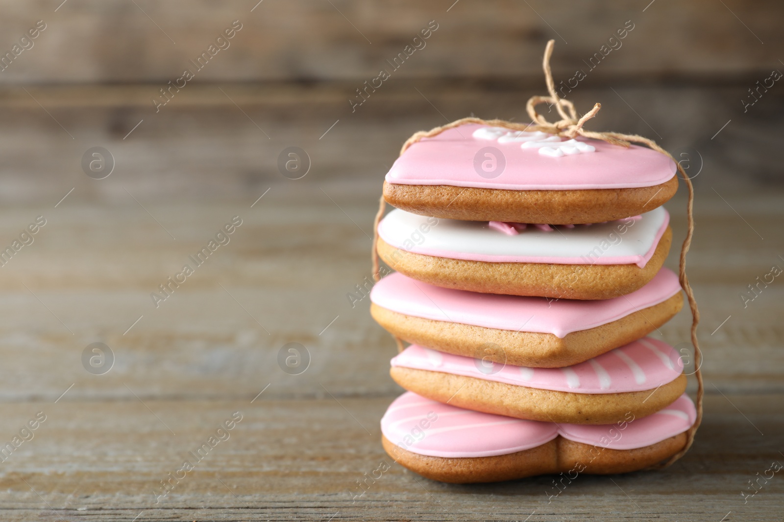 Photo of Stack of Valentine's day cookies on wooden table, closeup. Space for text