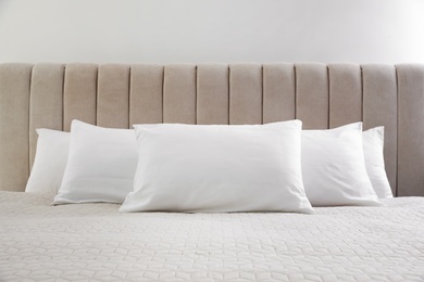 Photo of Many soft pillows on large comfortable bed