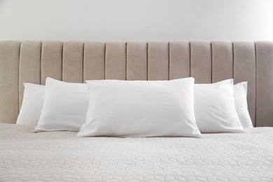 Many soft pillows on large comfortable bed