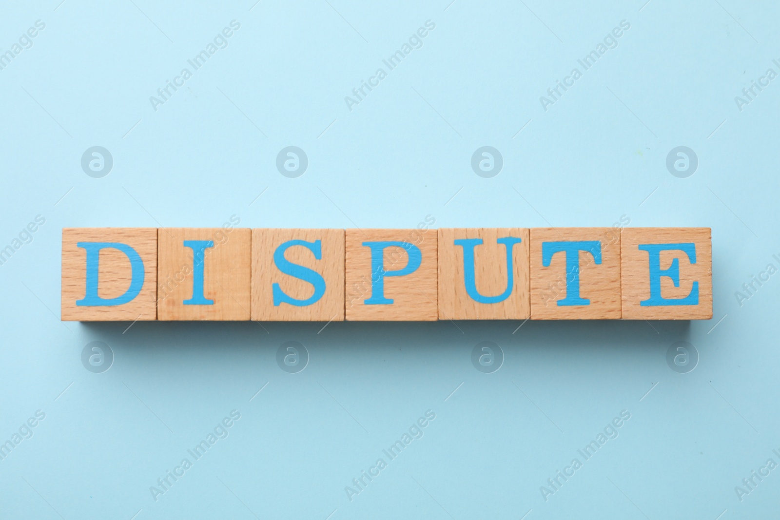 Photo of Cubes with word Dispute on light blue background, top view