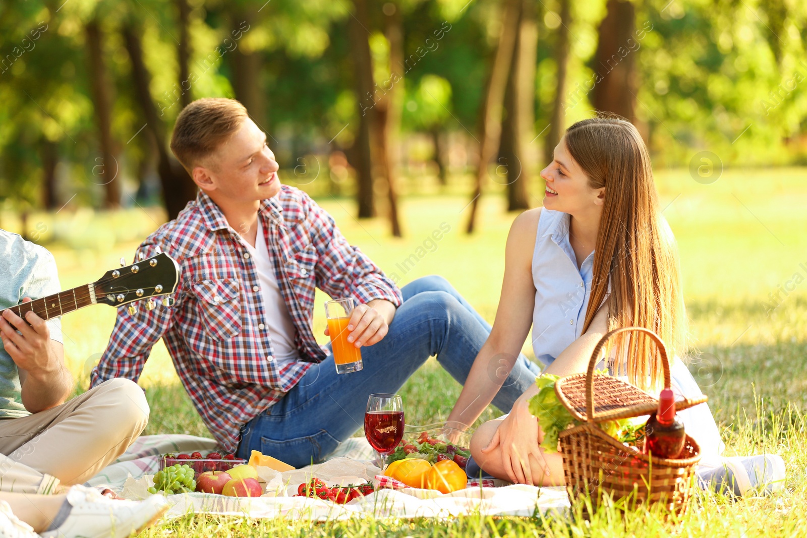 Photo of Young people enjoying picnic in park on summer day