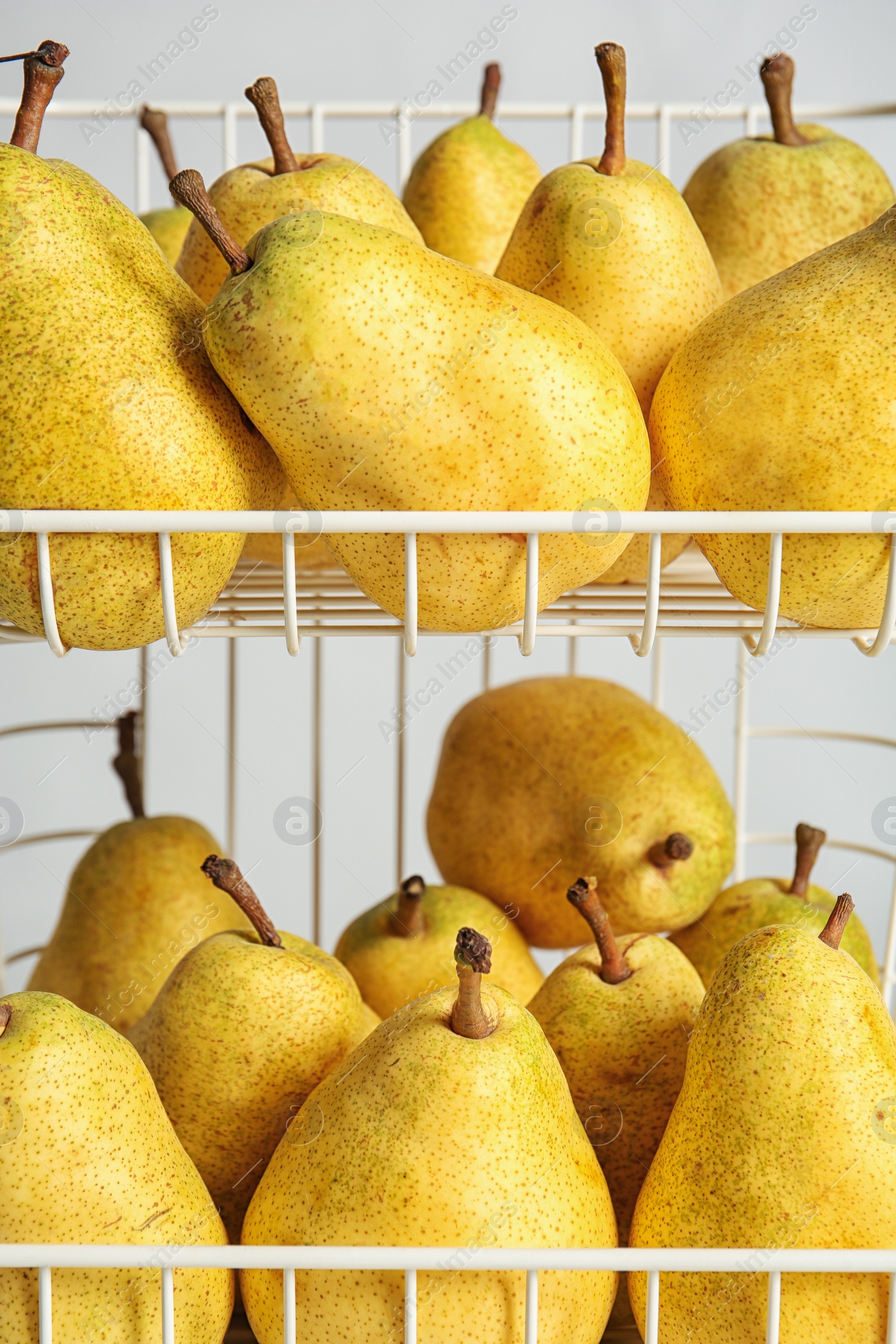 Photo of Basket with fresh ripe pears on light background, closeup view