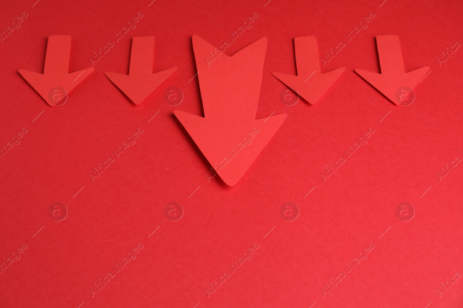Photo of Many paper arrows on red background, above view. Space for text