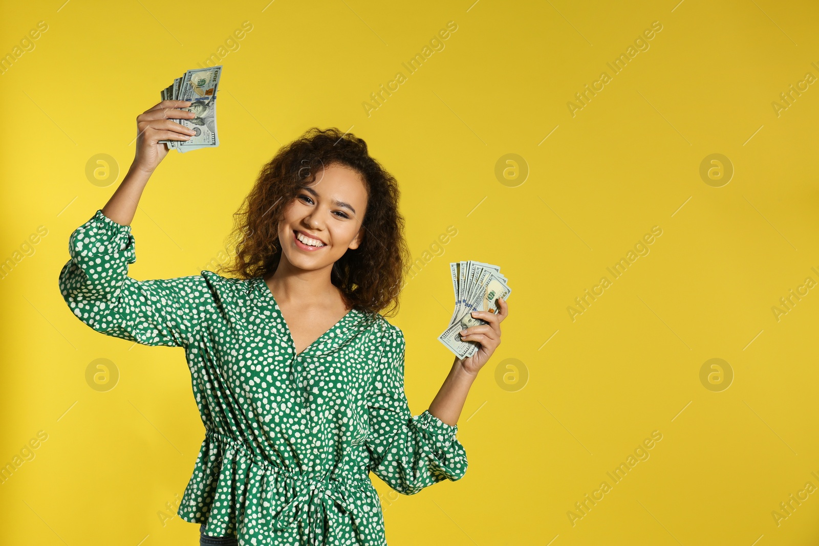 Photo of Young African-American woman with money on color background. Space for text