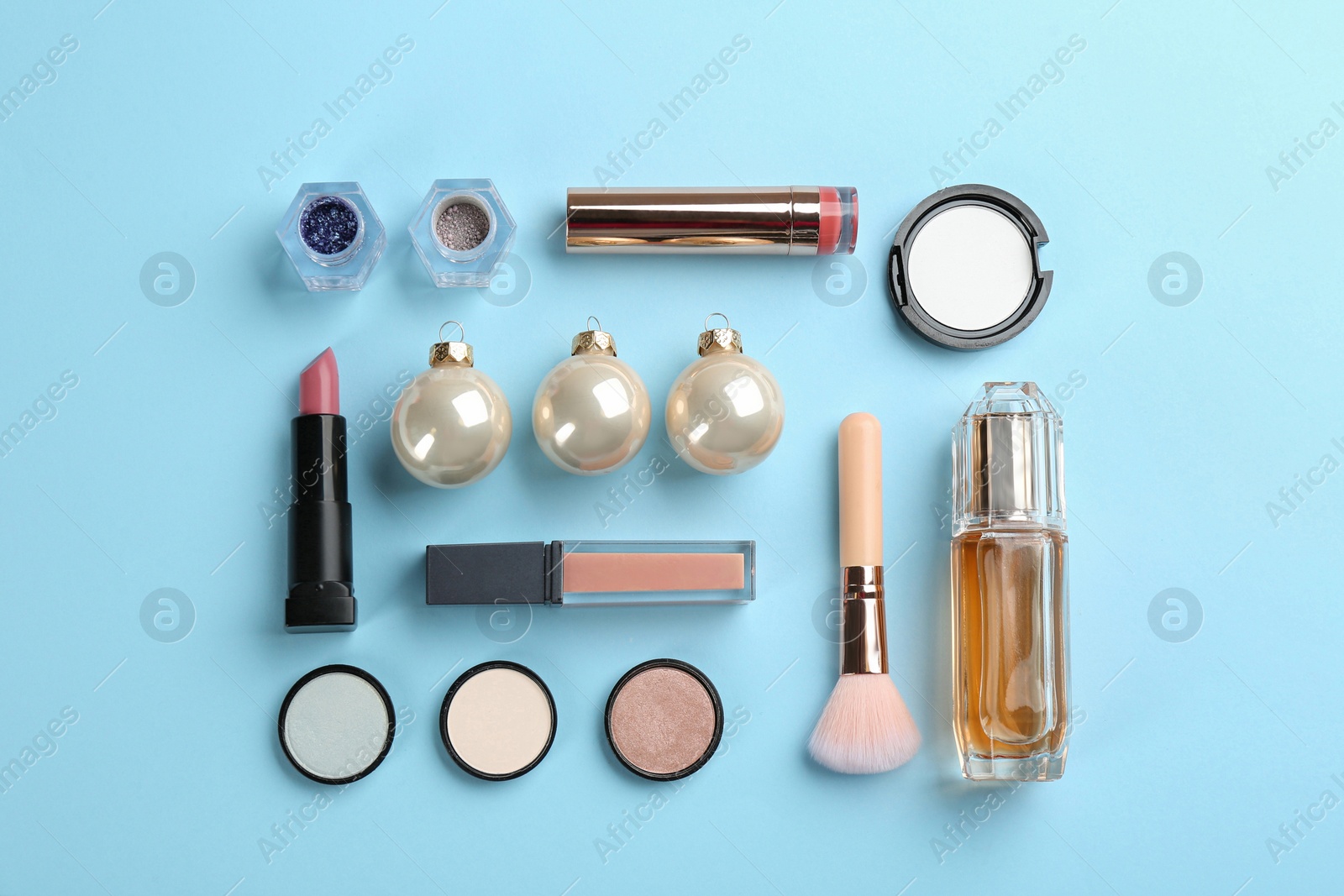 Photo of Flat lay composition with decorative cosmetic products on light blue background. Winter care