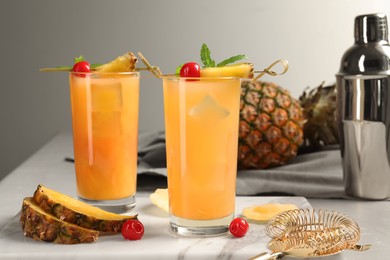 Photo of Tasty pineapple cocktail, fresh fruit and cherries on table