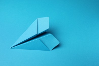 Photo of Handmade paper plane on light blue background, space for text