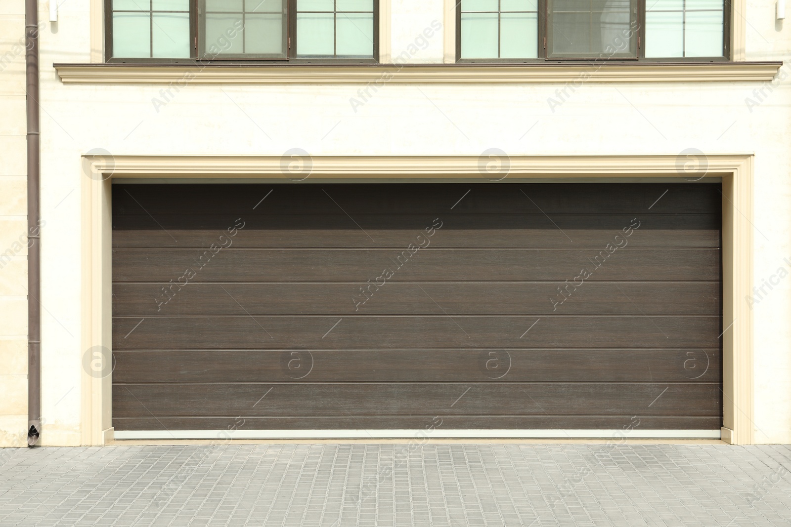 Photo of Building with wide brown sectional garage door on sunny day