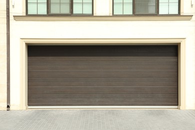 Building with wide brown sectional garage door on sunny day