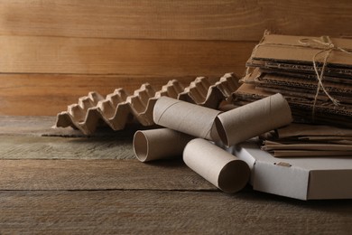 Photo of Different waste paper on wooden table, closeup. Space for text