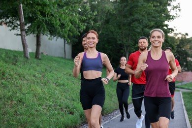 Photo of Group of people running outdoors. Active lifestyle