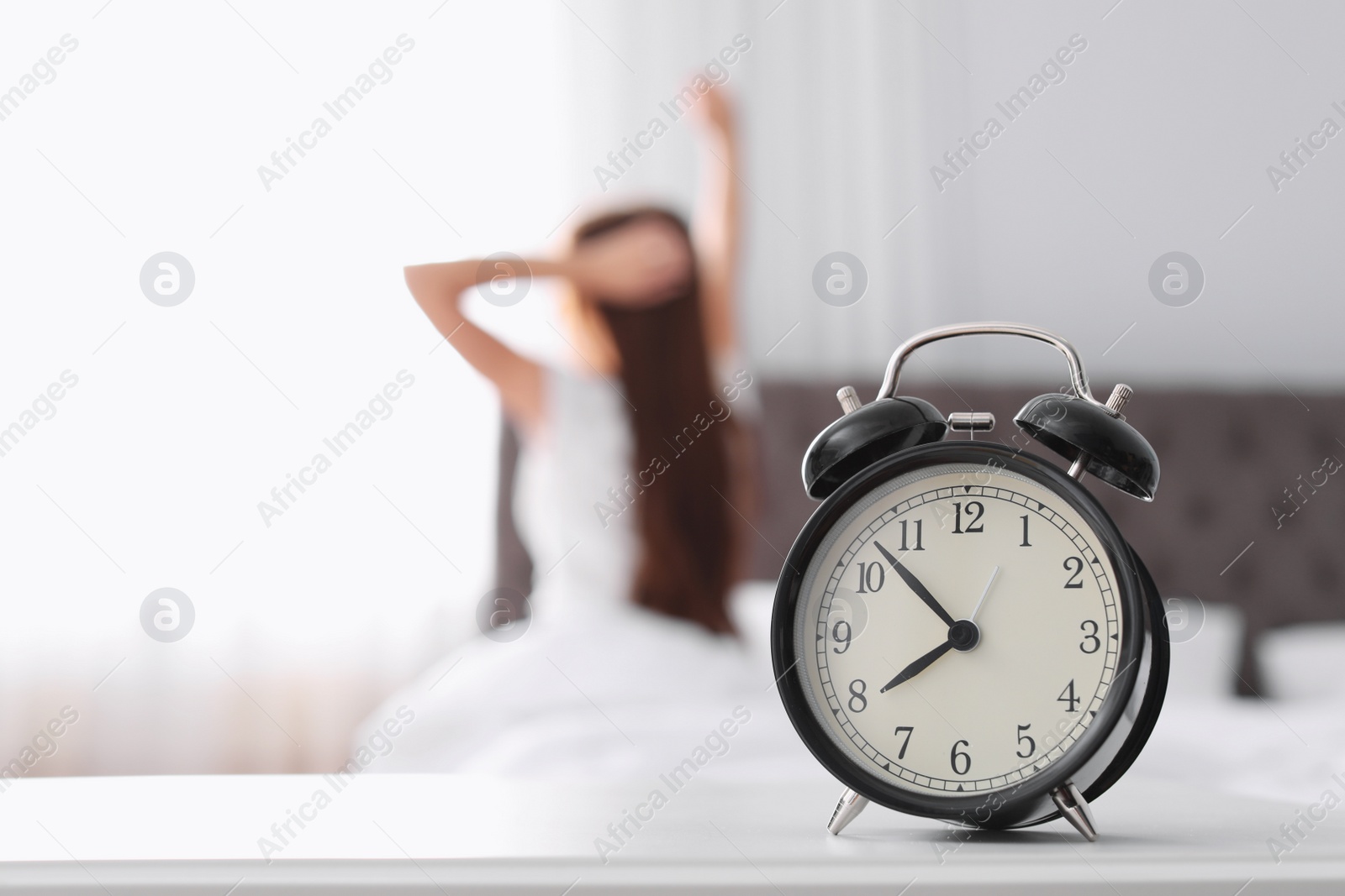 Photo of Alarm clock on table in bedroom. Time to wake up