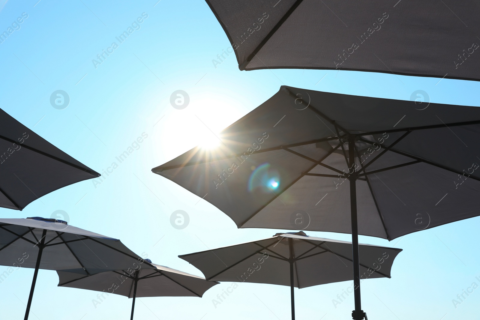 Photo of Beach umbrellas against blue sky on sunny day