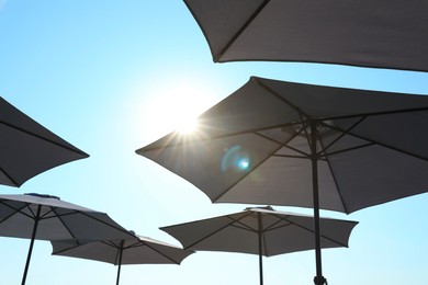 Beach umbrellas against blue sky on sunny day