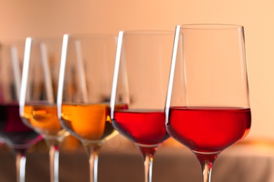 Row of glasses with different wines against blurred background, closeup