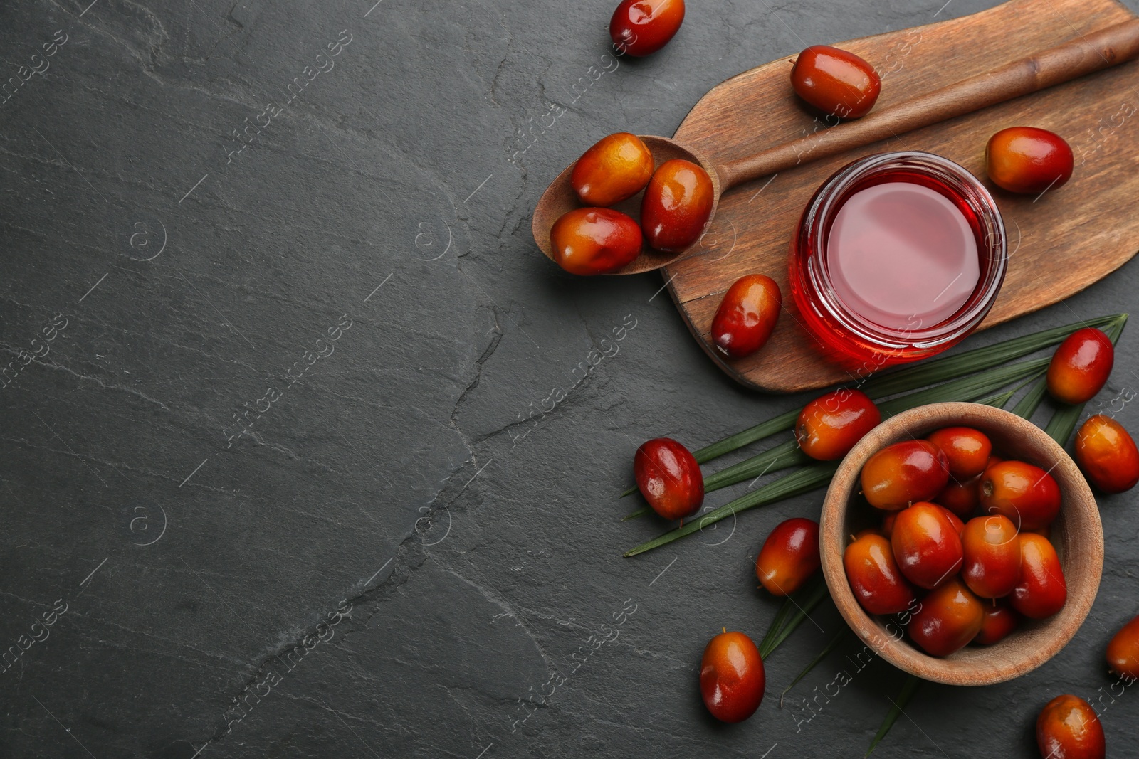 Photo of Flat lay composition with palm oil and fresh fruits on black table. Space for text