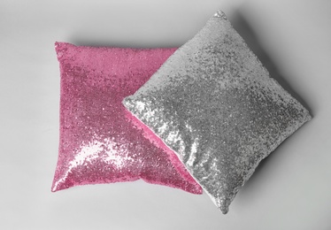 Photo of Shiny decorative pillows on light background