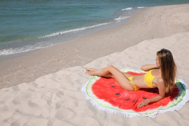 Photo of Woman with beach towel on sand near sea