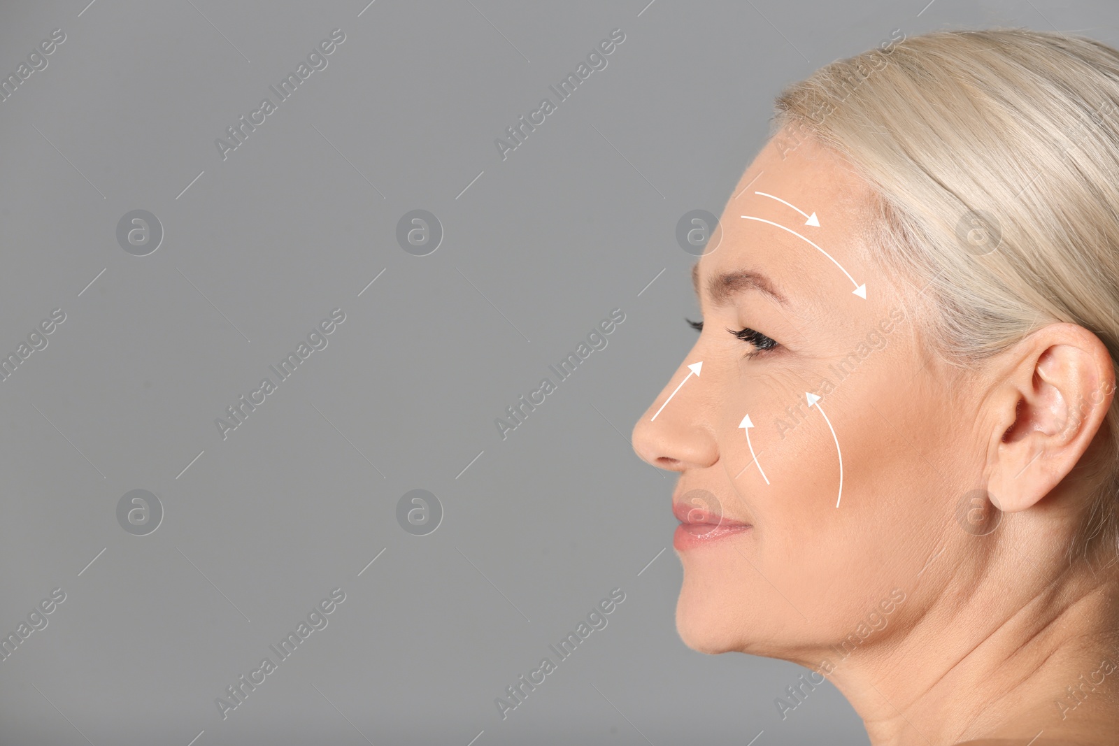 Image of Beautiful mature woman after facelift cosmetic surgery procedure on grey background. Space for text