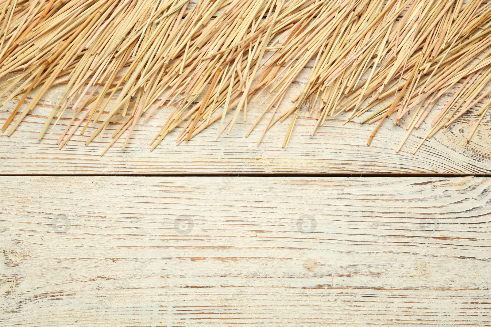 Photo of Heap of dried hay on white wooden background, flat lay. Space for text