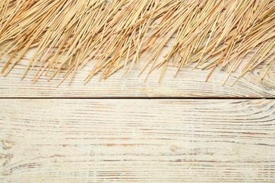 Photo of Heap of dried hay on white wooden background, flat lay. Space for text