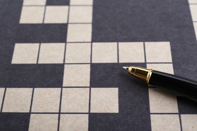 Photo of Pen on blank crossword, closeup. Space for text