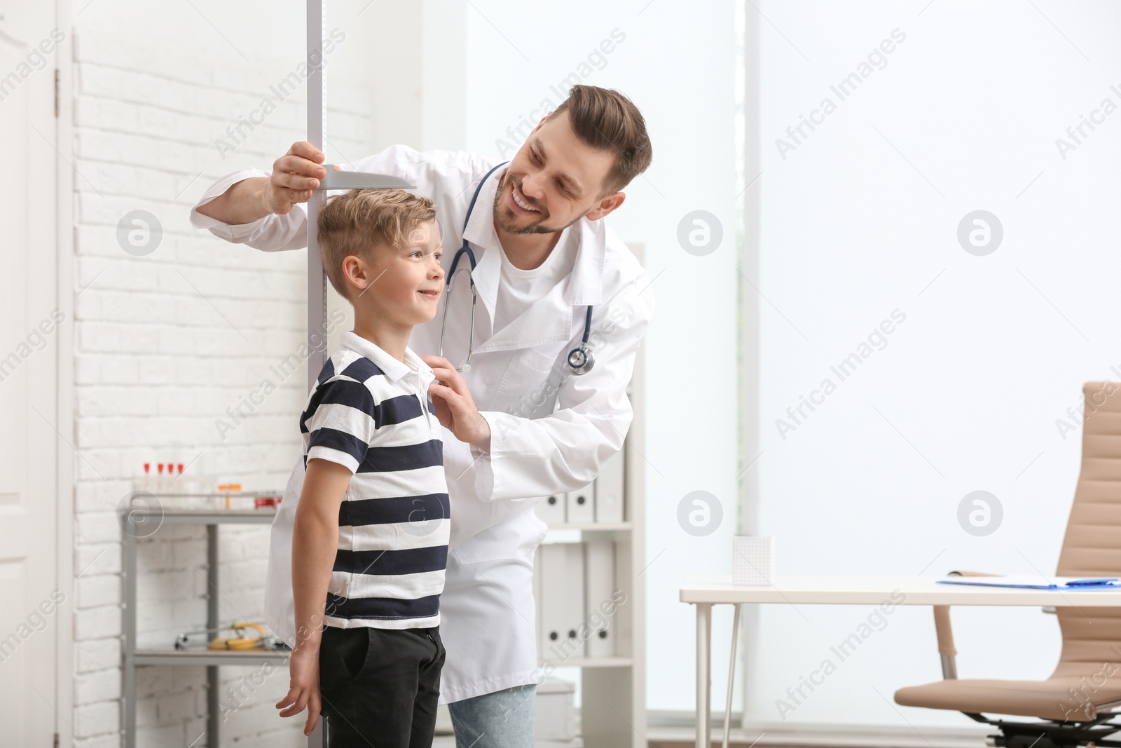 Photo of Doctor measuring little boy's height in hospital