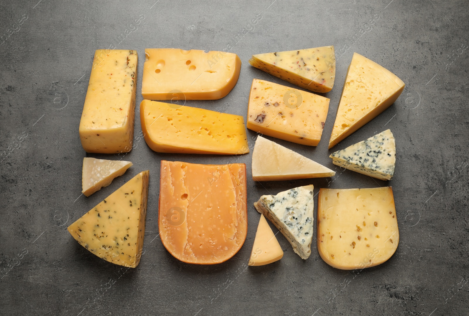 Photo of Different kinds of delicious cheese on stone background, top view