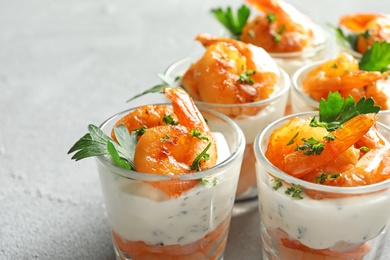 Photo of Glasses with fried shrimps and sauce on light background