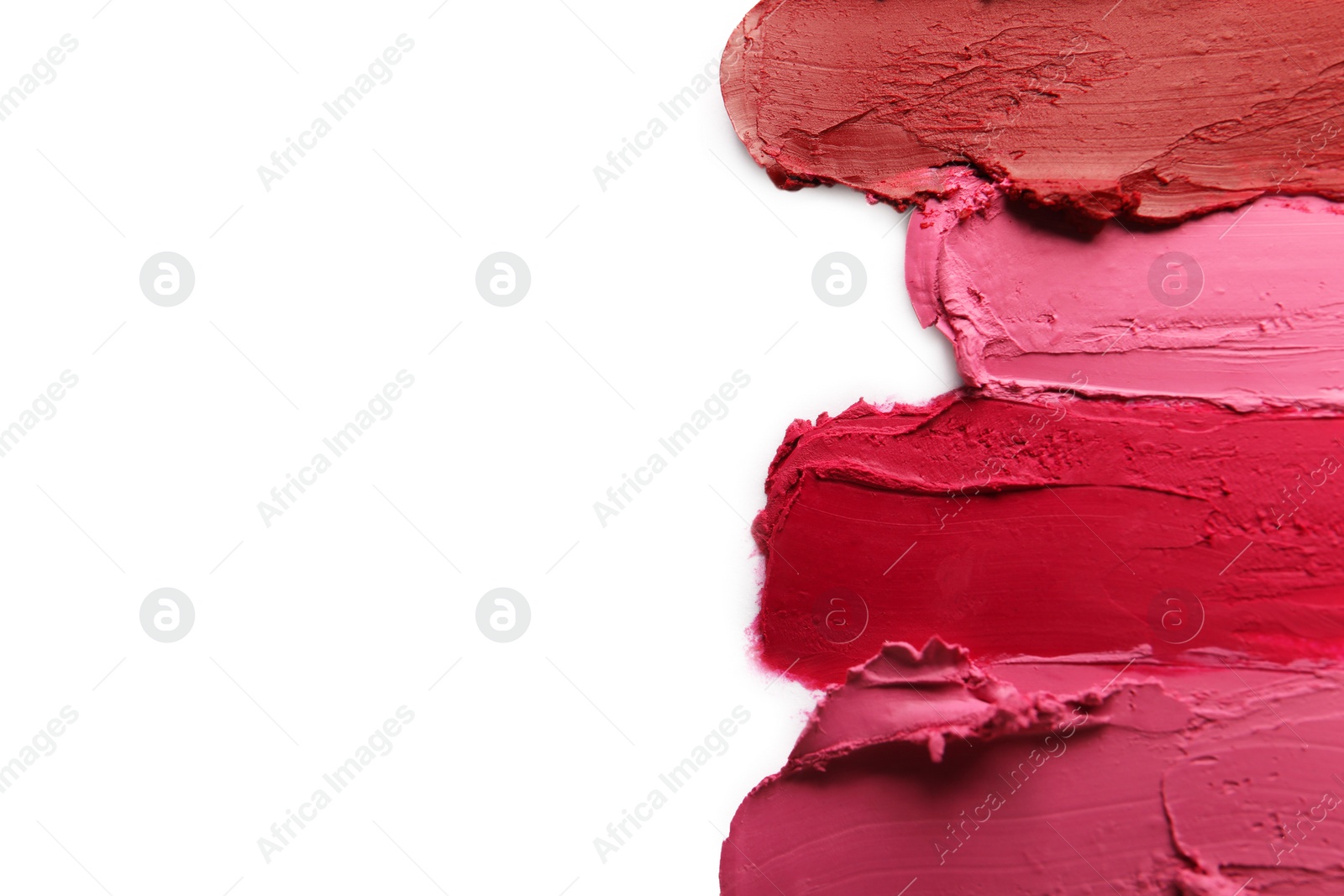 Photo of Smears of bright lipsticks on white background, top view