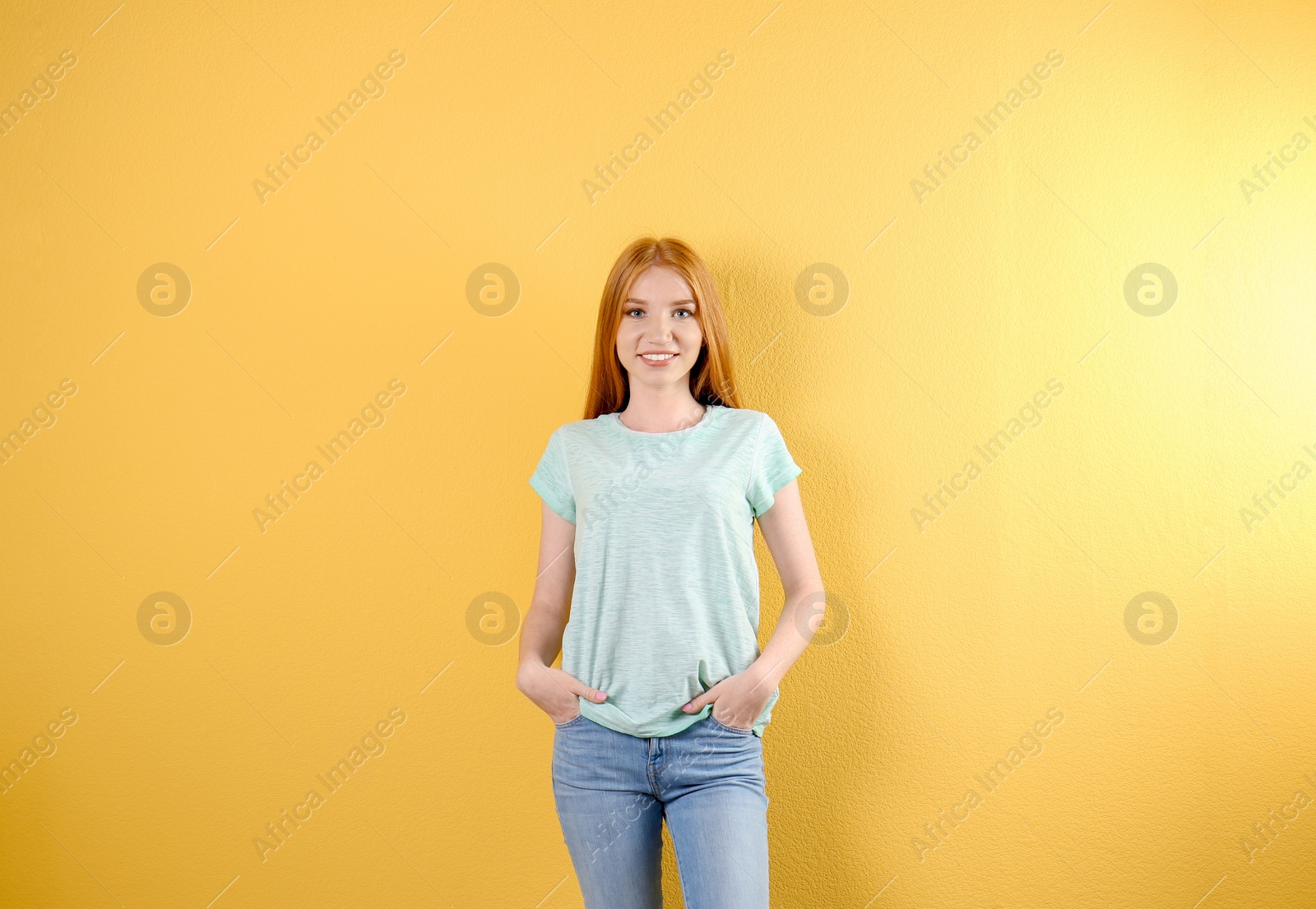 Photo of Young woman in stylish jeans on color background