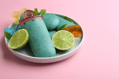 Plate with delicious spirulina popsicles and lime on color background. Space for text
