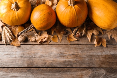 Ripe pumpkins on wooden background, flat lay with space for text. Holiday decoration