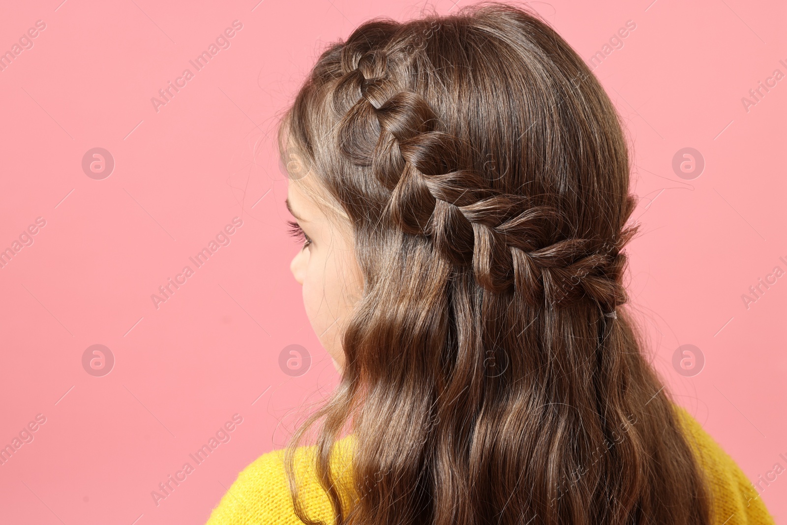 Photo of Little girl with braided hair on pink background, back view