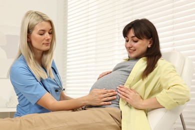 Photo of Pregnancy checkup. Doctor examining patient's tummy in clinic