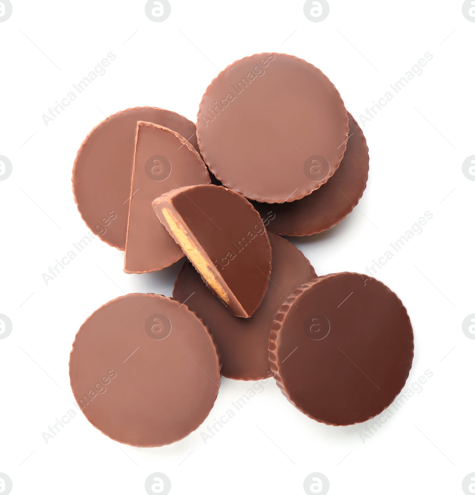 Photo of Cut and whole delicious peanut butter cups on white background, top view