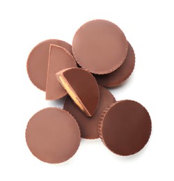 Photo of Cut and whole delicious peanut butter cups on white background, top view