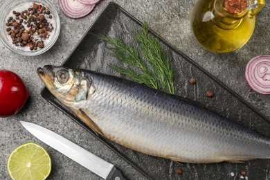 Photo of Delicious salted herring and ingredients on grey table, flat lay
