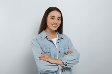 Portrait of happy young woman in jeans jacket on white background