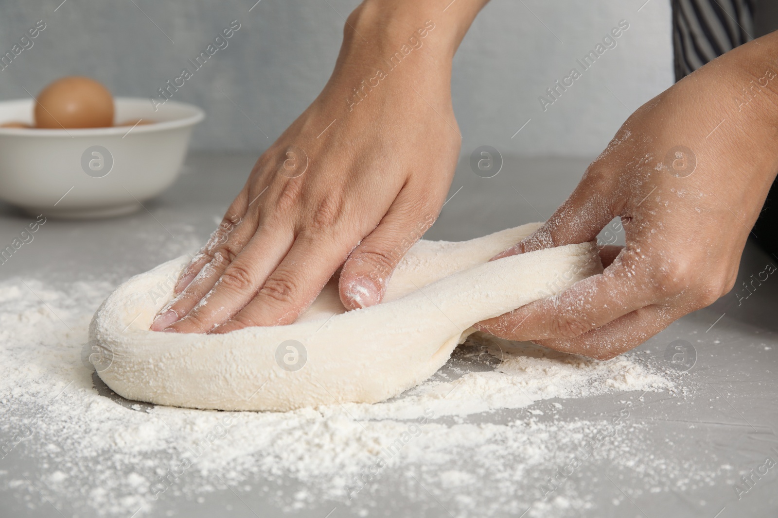 Photo of Woman kneading dough for pastry on table