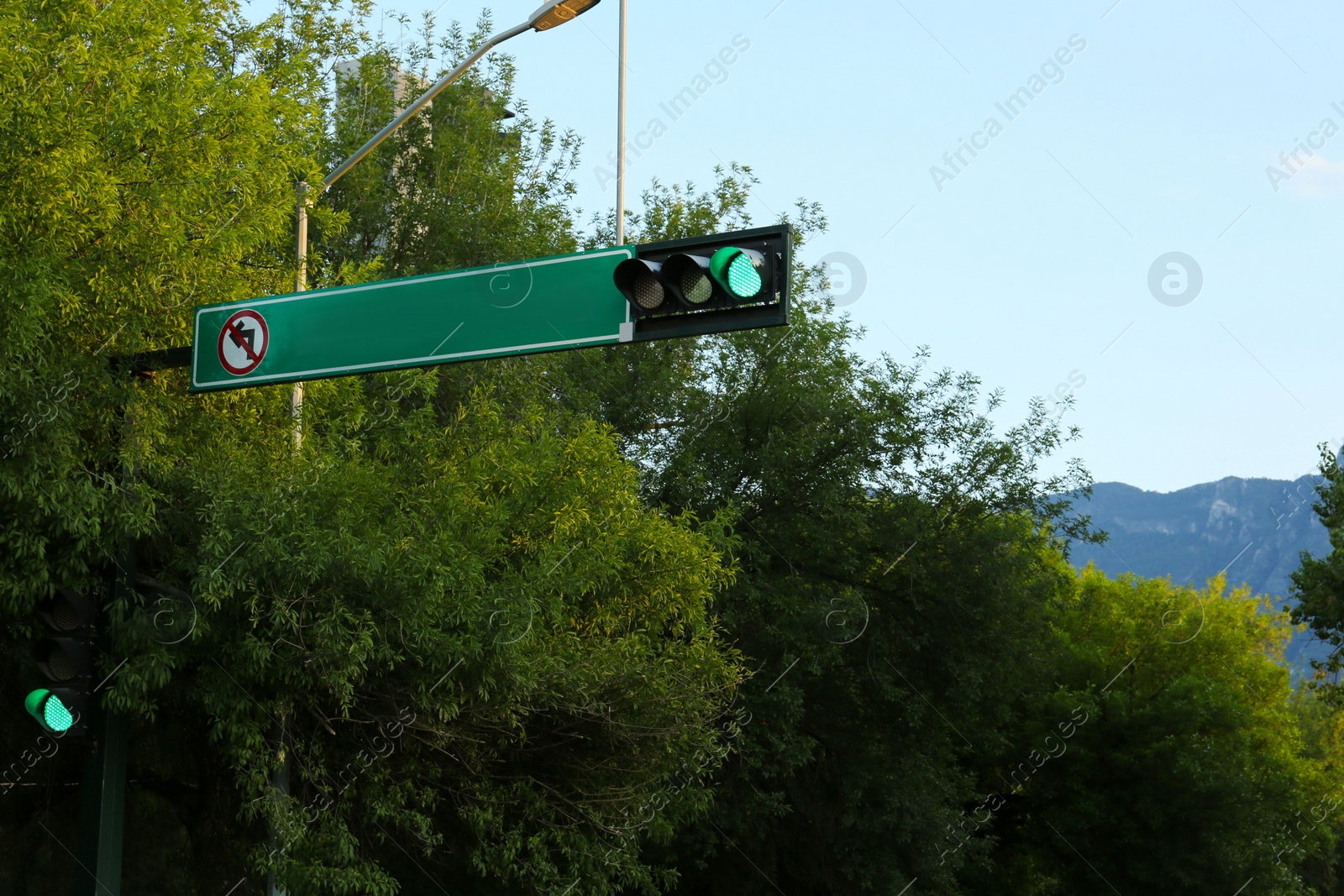 Photo of Post with green traffic light on city street