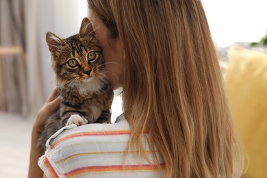 Photo of Woman with cat at home, closeup. Owner and pet