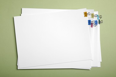 Sheets of paper with clips on light green background