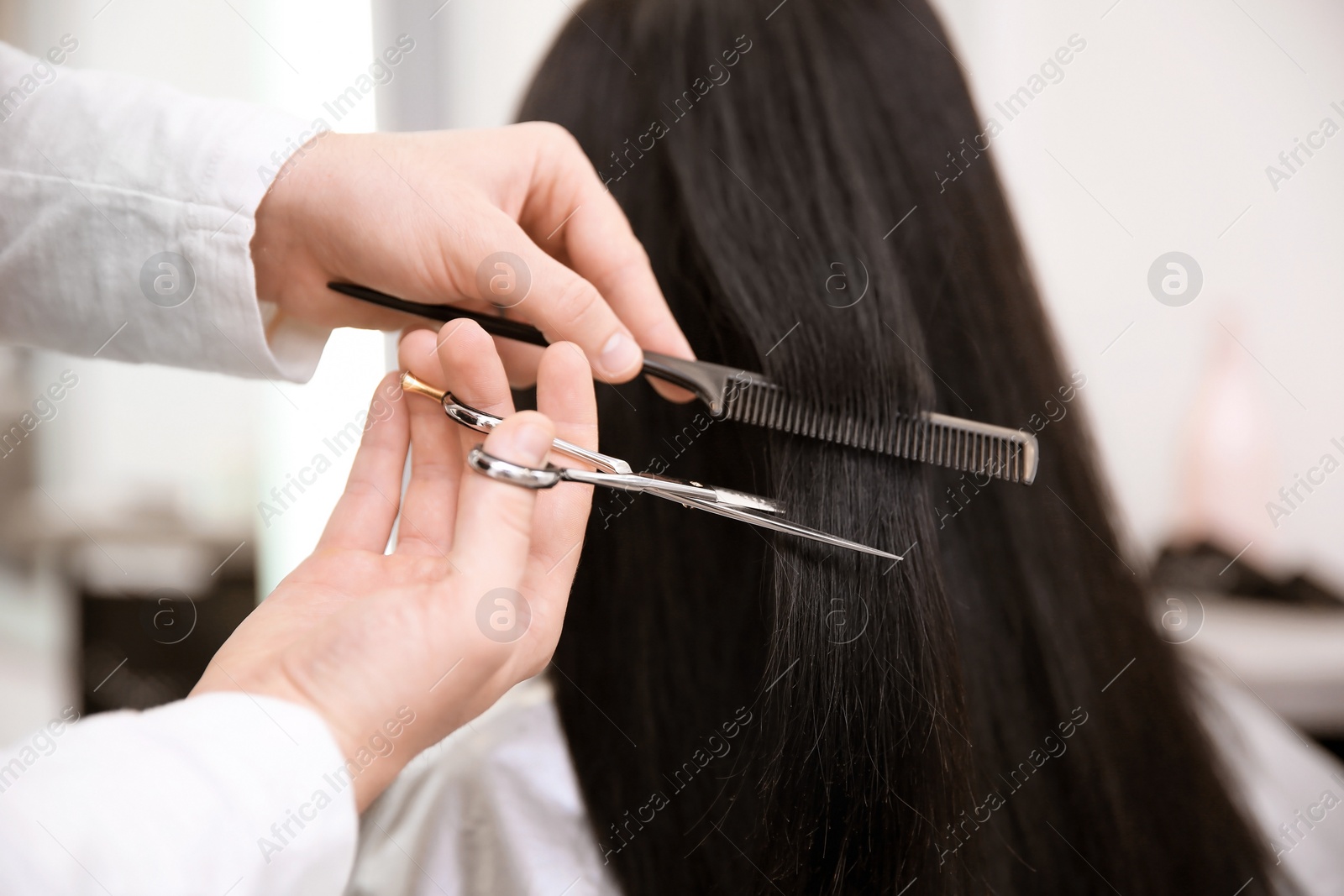 Photo of Professional male hairdresser working with client in salon